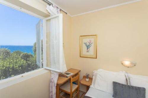 a bedroom with a window with a view of the ocean at La Casita Holiday Home in Petrcane