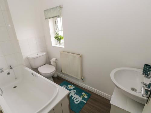 a white bathroom with a sink and a toilet at 39 Mariners Quay in Port Talbot