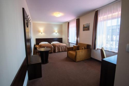 pokój hotelowy z łóżkiem i krzesłem w obiekcie Hotel Pod Szrenicą w Szklarskiej Porębie