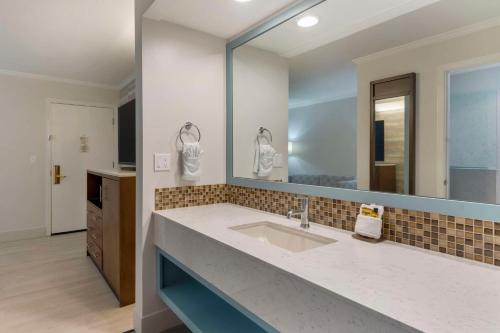 a bathroom with a sink and a large mirror at Best Western Plus All Suites Inn in Santa Cruz
