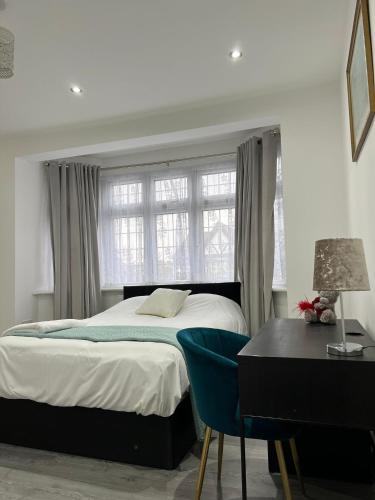 a bedroom with a bed and a desk and a window at Starlet Property in Wanstead