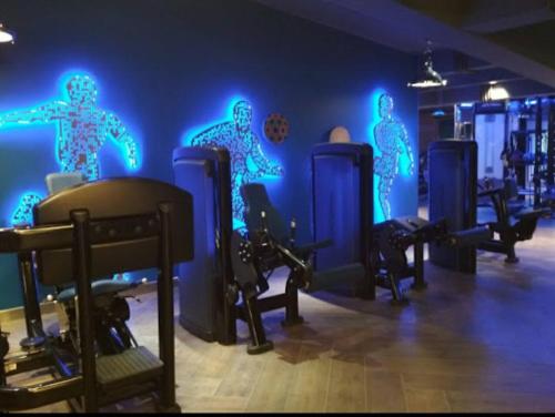 a gym with blue lights on the wall at Kanakia Paris D wing at BKC, Near Asian Heart Hospital, A Luxury Stay by Connekt Homes in Mumbai