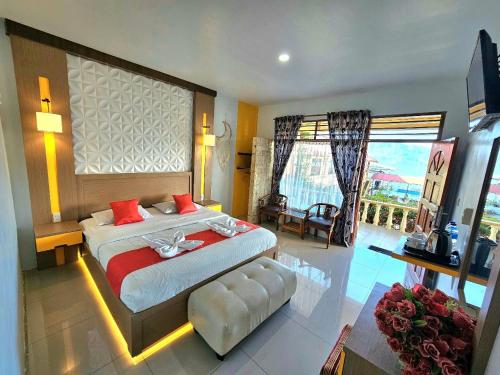 a bedroom with a large bed and a large window at Thyesza Hotel in Ambarita