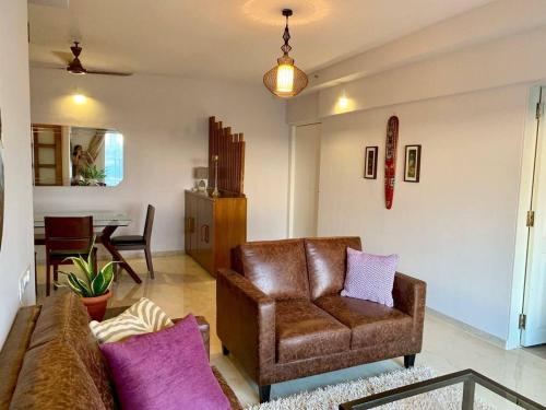 - un salon avec un canapé et une chaise dans l'établissement Kanakia Paris D wing at BKC, Near Asian Heart Hospital, A Luxury Stay by Connekt Homes, à Mumbai