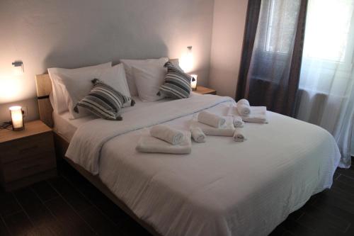 a bedroom with a white bed with towels on it at Ολόκληρο Διαμέρισμα η Βυσσινιά in Kotrónion
