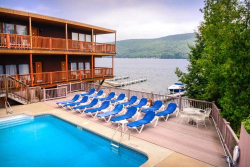 a hotel with a swimming pool and lounge chairs at Lake Crest Inn in Lake George