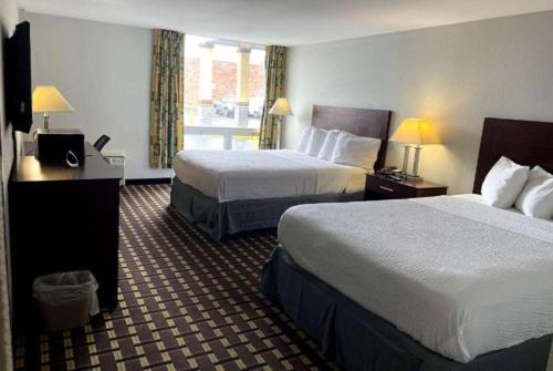 um quarto de hotel com duas camas e uma janela em Days Inn by Wyndham Fort Wright Cincinnati Area em Fort Wright