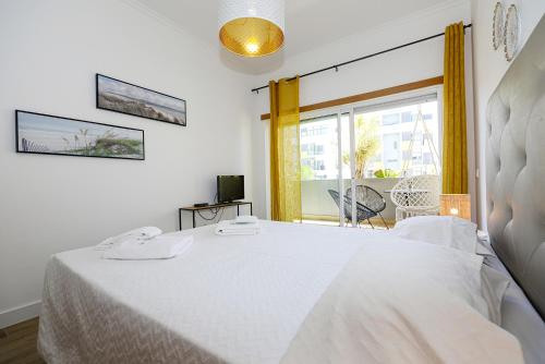 um quarto com uma cama branca e uma janela em B11 - Beach Way Apartment em Lagos