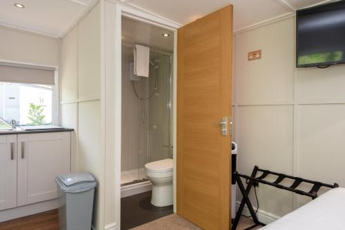 La salle de bains est pourvue de toilettes et d'une télévision. dans l'établissement Millie's Place, à Durham