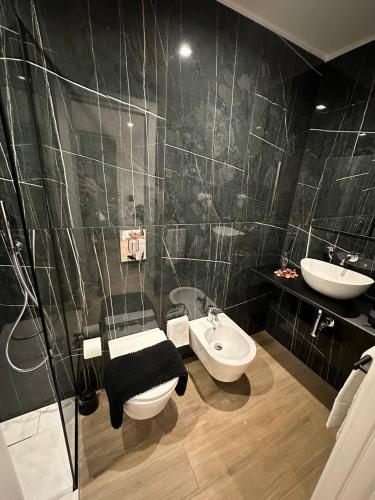 a bathroom with a sink and a toilet and a mirror at Black & White Rooms in Bari