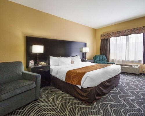 Habitación de hotel con cama y silla en Comfort Suites Lake Ray Hubbard, en Rowlett