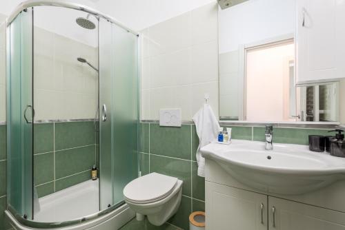 a bathroom with a sink and a toilet and a shower at Villa Oleander Apartman Aria in Poljane
