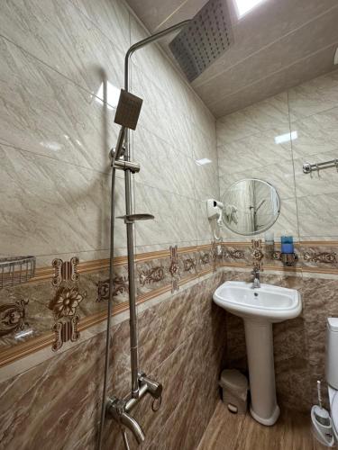 a bathroom with a sink and a shower with a mirror at Polaris Kazbegi in Stepantsminda