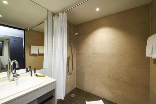 a bathroom with a shower and a sink and a tub at Ibis Styles Singen in Singen