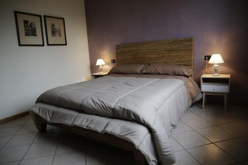ein Schlafzimmer mit einem großen Bett mit zwei Tischen und zwei Lampen in der Unterkunft 10 minutes to flight Orio al Serio BGY in Zanica