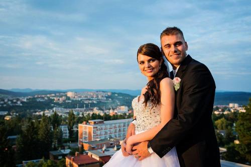 a bride and groom posing for a picture on a building at Hotel Tomášov in Zlín