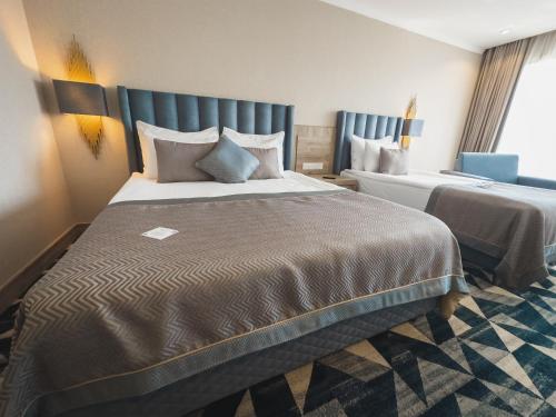 a hotel room with two beds and a window at The Arkin Iskele in Iskele