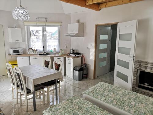 a kitchen with a table and chairs in a room at Agroturystyka Relaks in Orzeszkowo