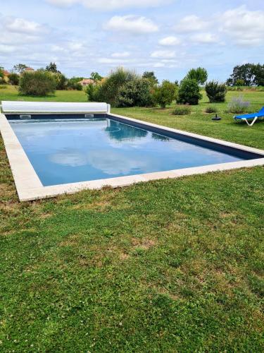 - une piscine au milieu d'une pelouse dans l'établissement charmant logement à la campagne, à Gazaupouy