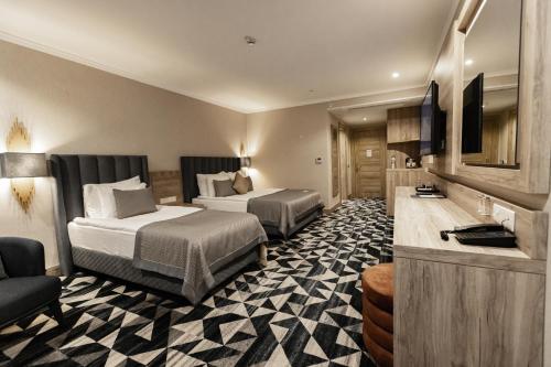 a hotel room with two beds and a television at The Arkin Iskele in Iskele