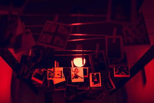 a chandelier with photos and a candle in a room at Anybody - Awarded love hotel in Brno