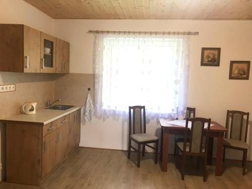 a kitchen and dining room with a table and a window at Apartmán Karhule (pod Blaníkem) in Pravonín