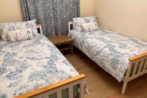 a room with two beds and a wooden table at 2 Bedroom Flat in Ardwick Manchester in Manchester