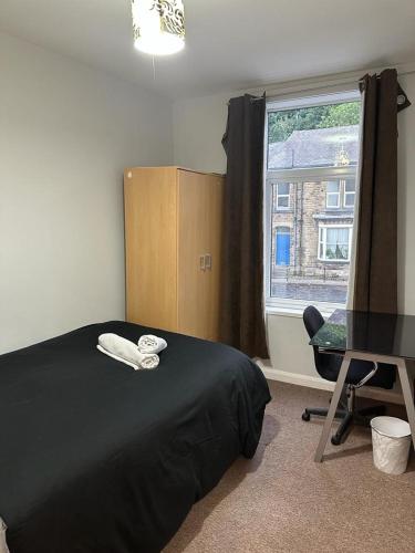 Schlafzimmer mit einem Bett, einem Schreibtisch und einem Fenster in der Unterkunft Ecclesall Suites in Nether Edge