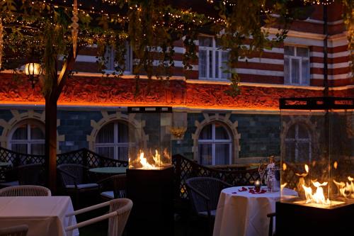 a restaurant with tables and chairs and fires in front of a building at Taj 51 Buckingham Gate Suites and Residences in London