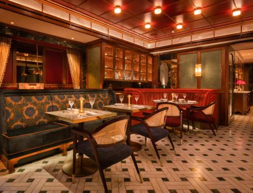 a restaurant with tables and chairs and a couch at Taj 51 Buckingham Gate Suites and Residences in London
