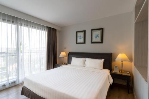 a bedroom with a white bed and a large window at Kantary Bay Hotel And Serviced Apartments Sriracha in Si Racha