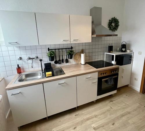 Perfekt für 5 - Stylisch & Zentral - Küche في إيسن: مطبخ مع دواليب بيضاء ومغسلة