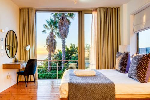 a bedroom with a bed and a large window with palm trees at Lobster Villa in Cape Town