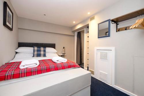 a bedroom with a bed with two towels at New Town Rooms in Edinburgh