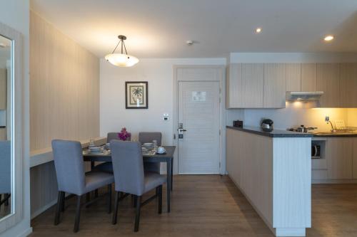 a kitchen and dining room with a table and chairs at Kantary Bay Hotel And Serviced Apartments Sriracha in Si Racha