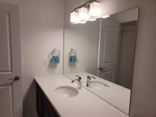a bathroom with a sink and a large mirror at Deluxe 3 Bedroom near Hyde Park mall & Western Uni in London