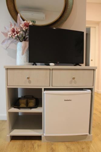 a entertainment center with a tv on top of it at Rito Hall da Serra in Leiria