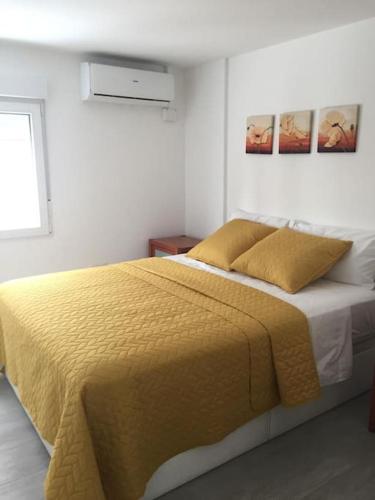 a bedroom with a large bed with a yellow blanket at NEW STYLISH BEACH FRONT APARTMENT in Cullera