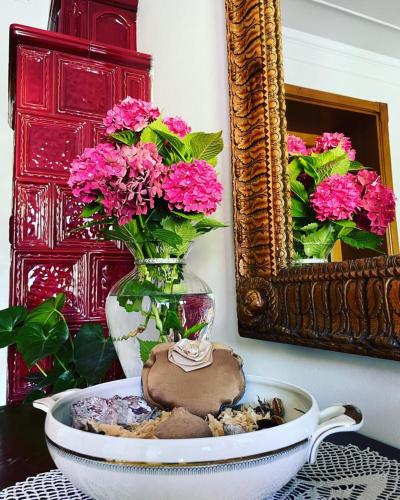a vase with pink flowers and a plate with a cookie at VILLA MARGHERITA in Pieve di Soligo