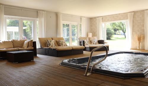 een woonkamer met een jacuzzi in het midden van de kamer bij Bozeat Retreat & York Cottage Spa in Bozeat