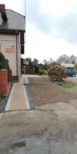 a parking lot with a car parked next to a building at Agroturystyka Relaks in Orzeszkowo