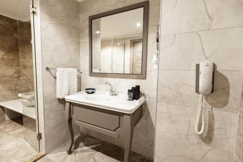a bathroom with a sink and a mirror and a shower at The Arkin Iskele in Iskele