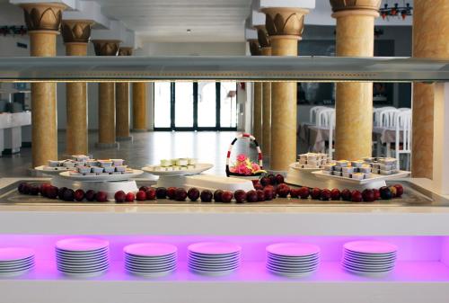 a buffet line with plates and desserts on display at TMK Marine Beach by Turismark in Triffa