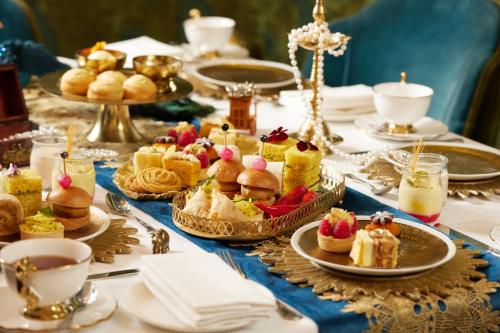 a table topped with plates of pastries and desserts at Taj 51 Buckingham Gate Suites and Residences in London