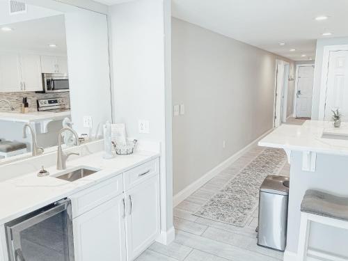 a white kitchen with a sink and a counter at Majestic Resort 505 with RESERVED parking on 3rd Floor Walk-Over in Panama City Beach