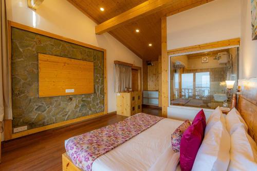 a bedroom with a bed and a stone wall at StayVista at DAAFI House with Comp Breakfast in Theog