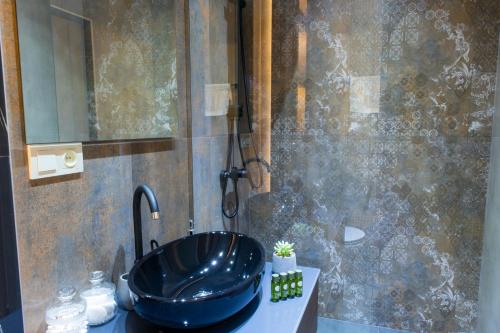 ein Bad mit einem schwarzen Waschbecken und einer Dusche in der Unterkunft hotelise I Leo Apartment in Yerevan