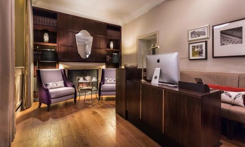 a living room with a couch and a desk with a computer at Taj 51 Buckingham Gate Suites and Residences in London