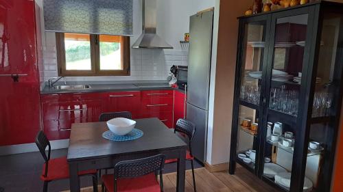 a kitchen with red cabinets and a table with a bowl on it at La Casita de Tití in Pravia