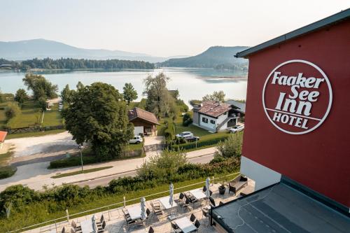 a hotel sign with a view of a lake at Hotel Faaker See Inn by S4Y in Faak am See